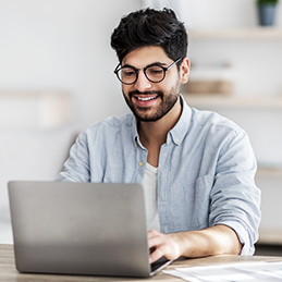 Person tippt auf einem Laptop